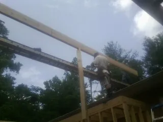 Carpenter setting a ridge beam over a new addition frame — Ice Dam Removal by Roofing Brothers in Landisburg
