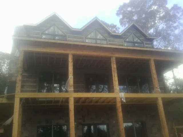 Dormers and porch framing on a large log home under construction — Roof Coating work by our crew in Landisburg