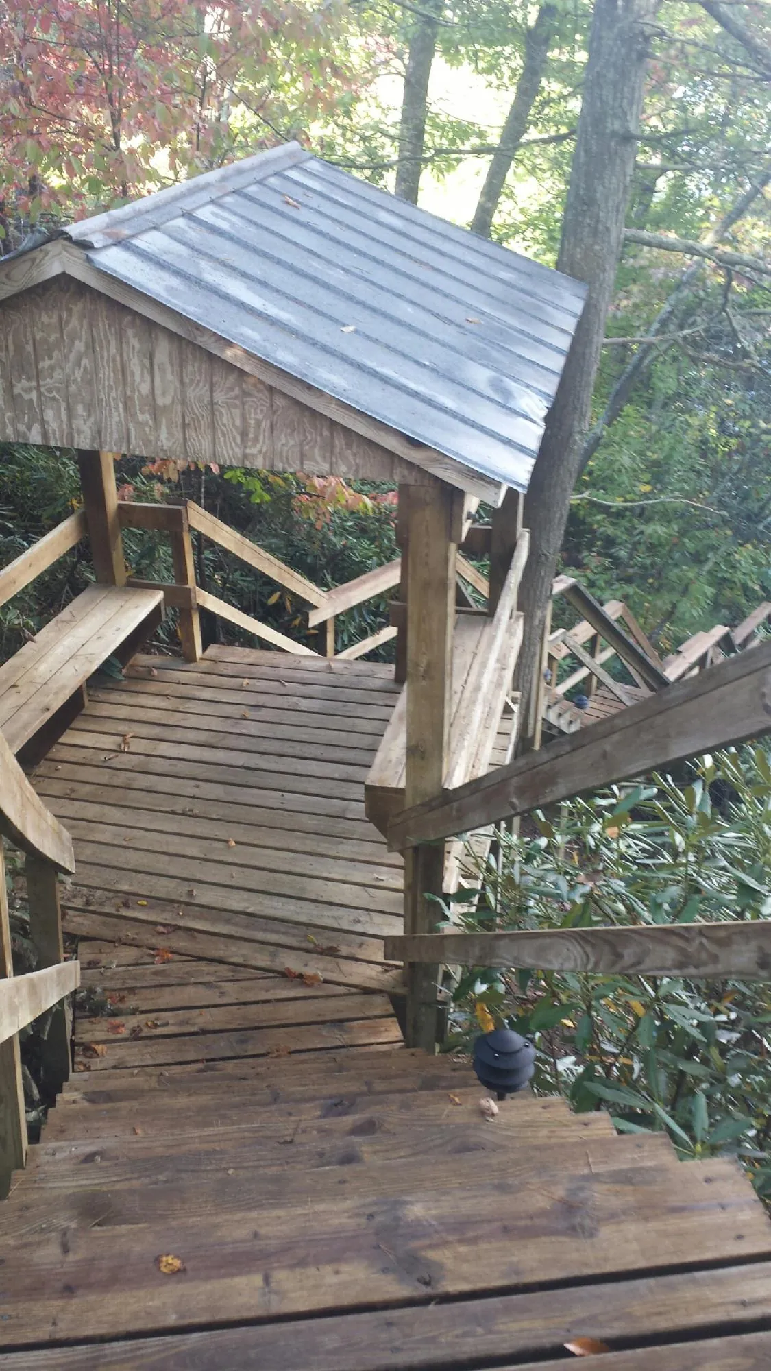 Metal roofed shelter over wooden steps on a wooded walkway — Skylight Repair & Installation work by our crew in Landisburg